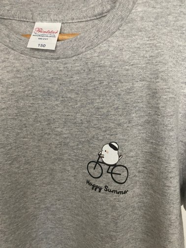 シマエナガと黒い自転車と黒いロゴのTシャツのロゴをアップにした写真です。